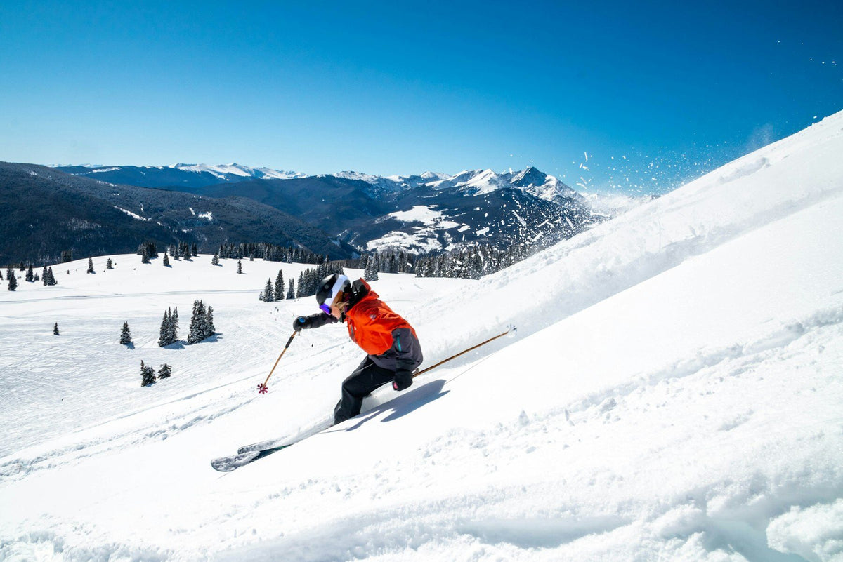 Skier carving down a groomed slope